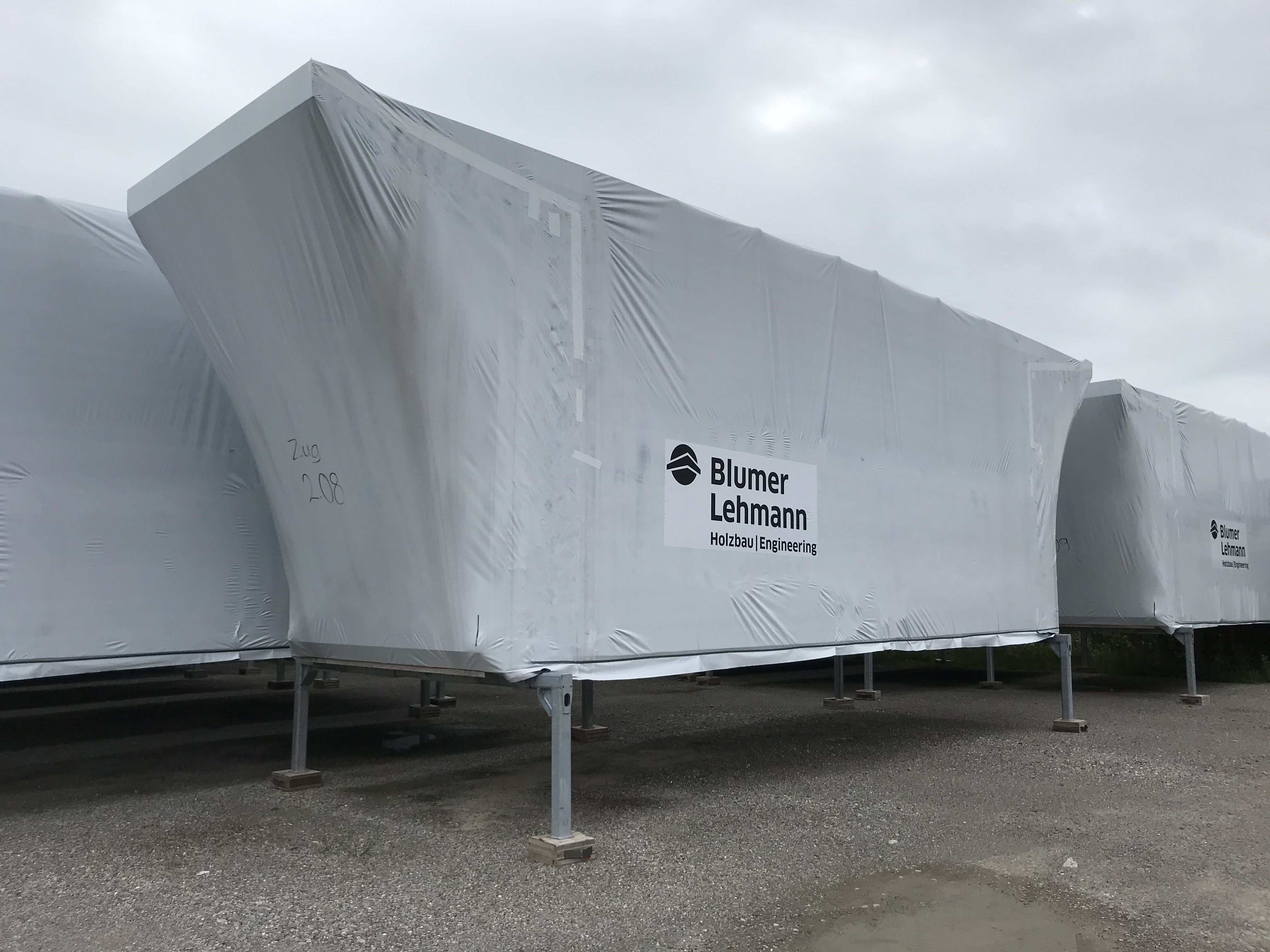 Holzelemente auf Pritschen regensicher verpackt, Parkplatz in Zuzwil SG
